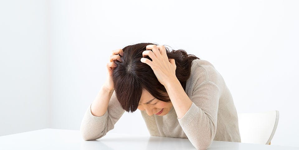 頭を抱えている女性